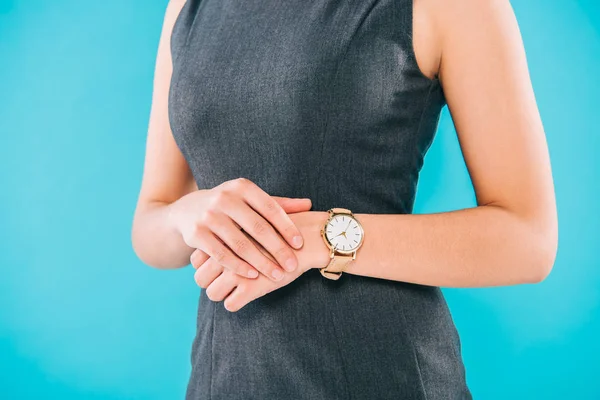 Cropped shot of young woman in grey dress and watch isolated on blue — Stock Photo