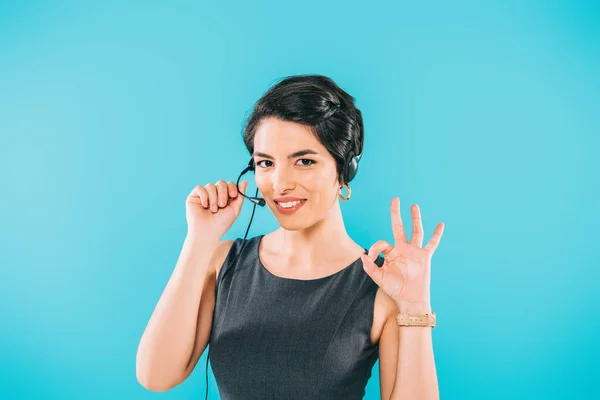 Operador de centro de llamadas de raza bastante mixta en auriculares que muestran signo de ok mientras mira la cámara aislada en azul — Stock Photo