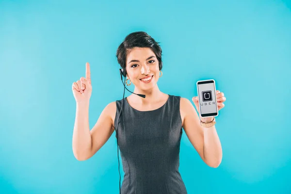 KYIV, UKRAINE - APRIL 24, 2019: Smiling mixed race call center operator holding smartphone with Skype app on screen and showing idea sign isolated on blue. — Stock Photo