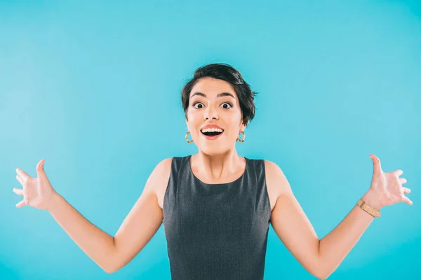 Excitada mujer de raza mixta haciendo gestos mientras mira la cámara aislada en azul - foto de stock