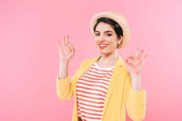 Sorrindo mulher de raça mista mostrando ok canta enquanto olha para a câmera isolada no rosa — Fotografia de Stock