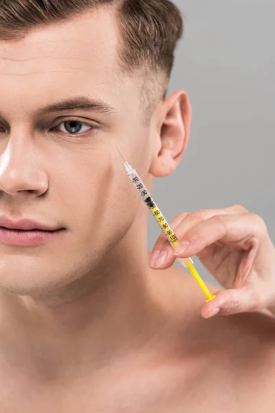 Partial view of cosmetologist holding syringe and young man isolated on grey — Stock Photo