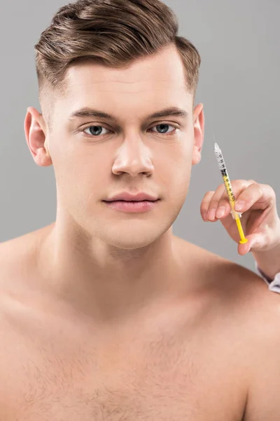 Kosmetikerin mit Spritze und junger Mann isoliert auf Grau — Stockfoto