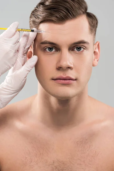 Vue partielle du cosmétologue dans des gants en latex faisant une injection de beauté isolé sur gris — Photo de stock