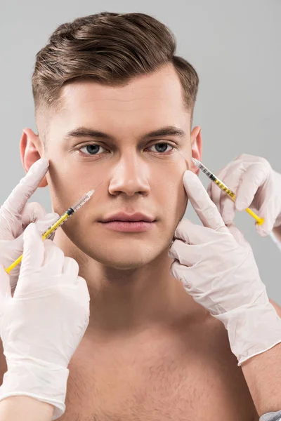 Cropped view of cosmetologists in latex gloves doing beauty injections isolated on grey — Stock Photo