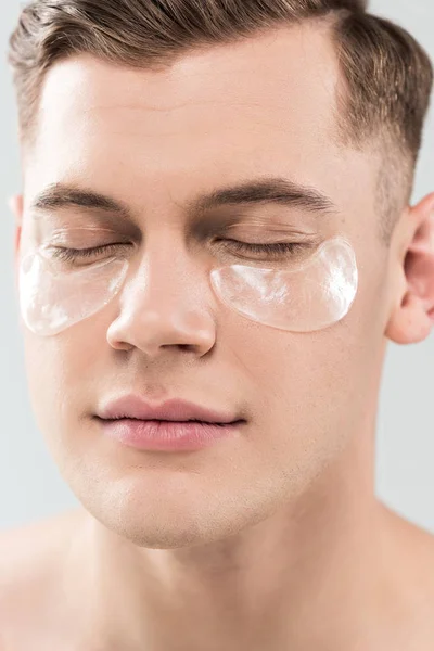 Portrait of handsome young man with eye patches isolated on grey — Stock Photo