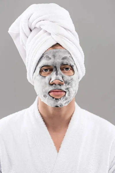 Front view of man in bathrobe with facial mask isolated on grey — Stock Photo