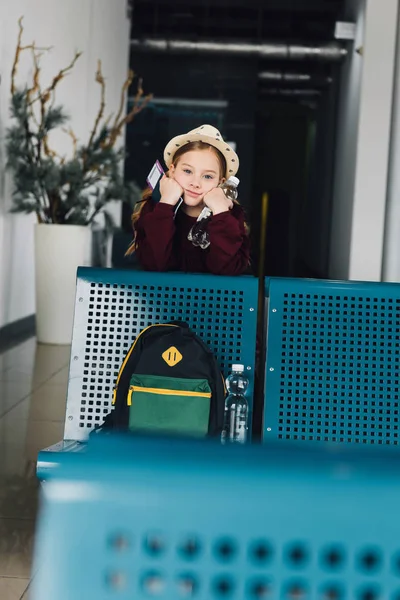 Чарівна дівчинка з паспортом і авіаквитком в залі очікування — стокове фото