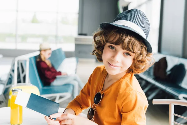 Lindo niño preadolescente con pasaporte y billete de avión en el aeropuerto - foto de stock