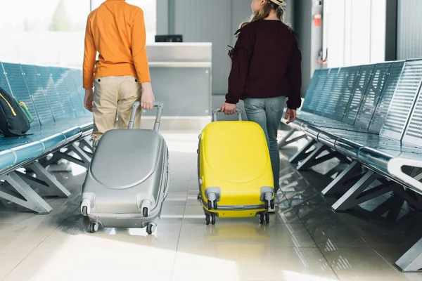 Задний вид на подростков с чемоданами в зале ожидания — стоковое фото