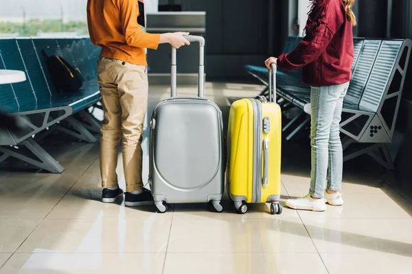 Back view of preteen kids with suitcases in waiting hall — Stock Photo