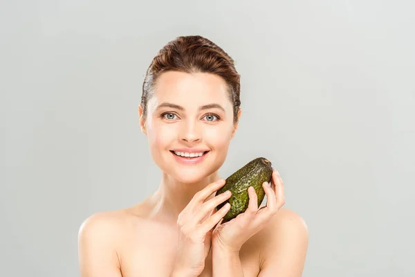 Веселая голая женщина, держащая органический и спелый авокадо, изолированный на сером — стоковое фото
