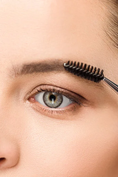 Abgeschnittene Ansicht einer Frau, die Augenbrauen mit einem Augenbrauenpinsel gestaltet — Stockfoto