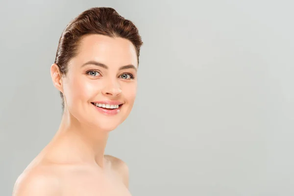 Positive and naked woman looking at camera while smiling isolated on grey — Stock Photo