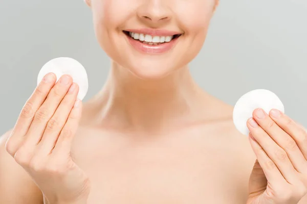 Vista recortada de mujer desnuda feliz sosteniendo almohadillas de algodón aisladas en gris - foto de stock