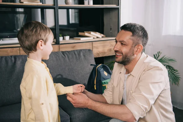 Feliz sorrindo pai pai ajustando camisa do filho em casa — Fotografia de Stock