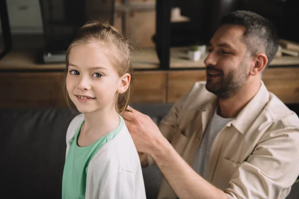 Enfoque selectivo de sonriente padre tejiendo escuchar de adorable hija — Stock Photo