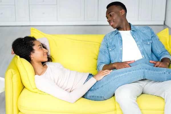 Africano americano mulher deitada no sofá e olhando para o namorado — Fotografia de Stock