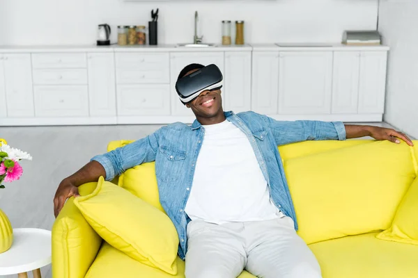 High angle view of african american man sitting on couch in vr headset — Stock Photo