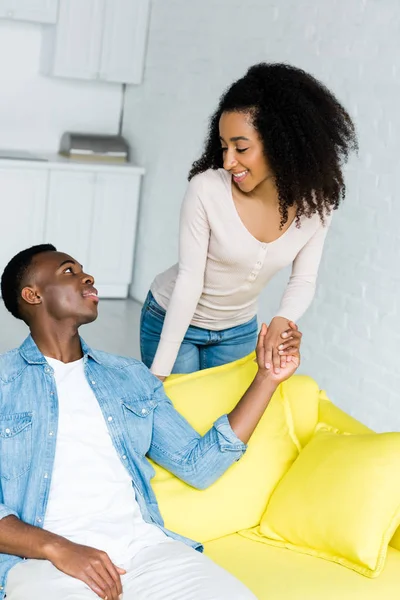 Vue grand angle du couple afro-américain tenant la main et regardant vers l'autre — Photo de stock