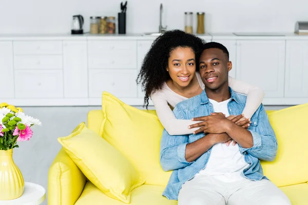 African american woman hugging boyfriend and looking at camera — Stock Photo
