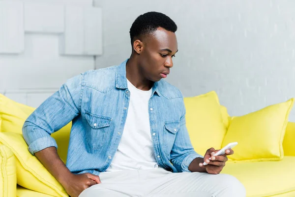 Боковой вид африканского мужчины с помощью смартфона — Stock Photo