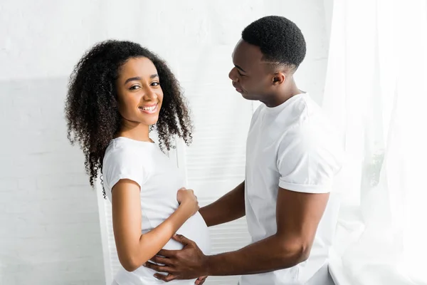 Seitenansicht von afrikanisch-amerikanischen Mann berührt Bauch schwangere Freundin — Stockfoto