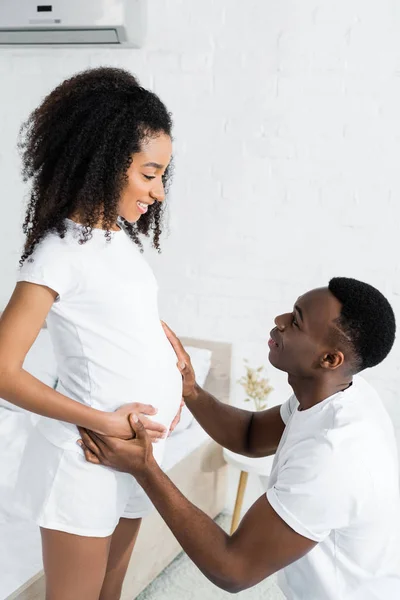 Vue latérale de la femme enceinte afro-américaine regardant son petit ami — Photo de stock