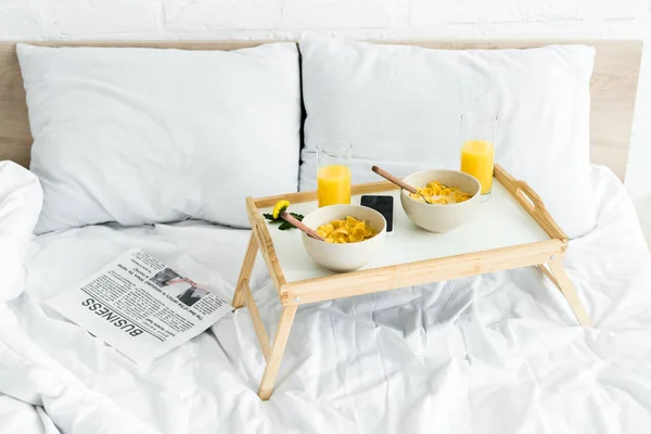 High angle view of tray table with breakfast on white bed in bright room — Stock Photo