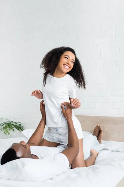 Happy african american couple spending time together, lying on bed at home — Stock Photo