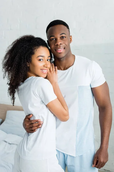 Happy african american woman cuddling to handsome boyfriend, looking at camera — Stock Photo