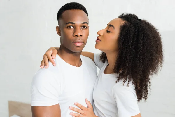 Serious african american man looking at camera, standing near attractive girlfriend — Stock Photo