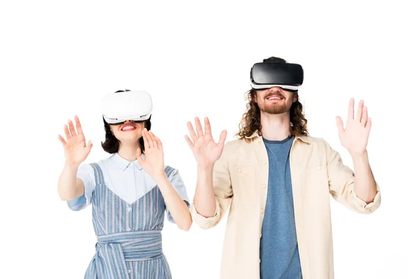 Joven hombre y chica con auriculares VR levantando las manos en el aire aislado en blanco - foto de stock