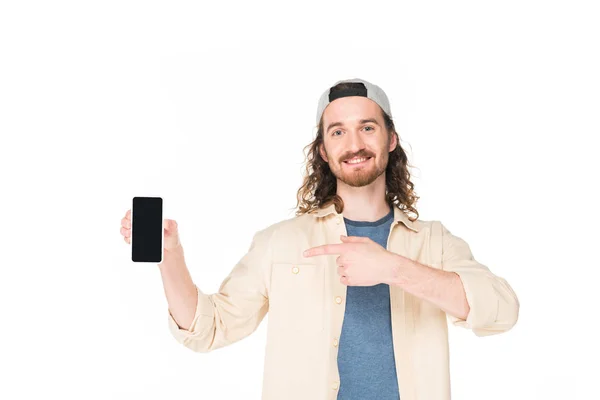 Молодий чоловік тримає смартфон в руках і посміхається ізольовано на білому — стокове фото
