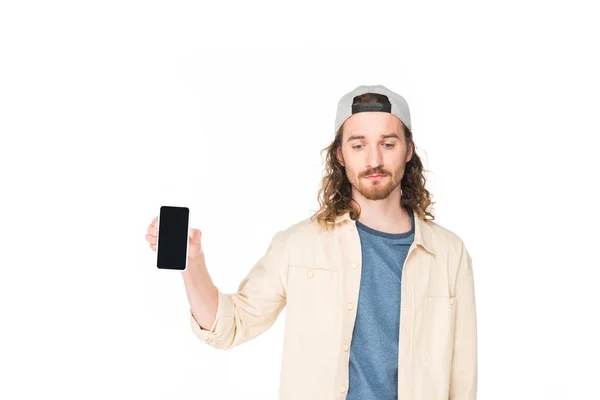 Triste jeune homme tenant smartphone dans les mains et regardant vers le bas isolé sur blanc — Photo de stock