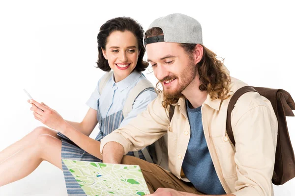 Beautiful girl smiling while young man looking at map isolated on white — Stock Photo