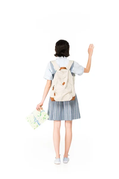 Вид ззаду дівчини махає рукою і тримає карту ізольовано на білому — стокове фото