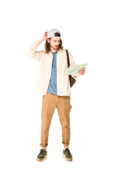 Full length view of confused young man holding map isolated on white — Stock Photo