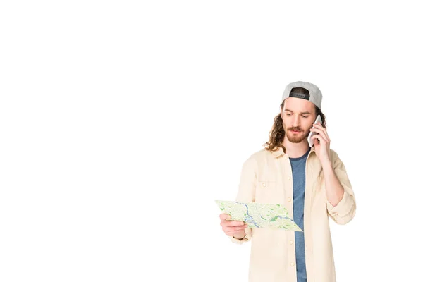Young man looking at map and talking on smartphone isolated on white — Stock Photo