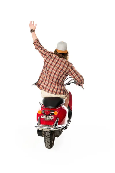 Vista trasera del joven con la mano en el aire sentado en scooter rojo aislado en blanco - foto de stock