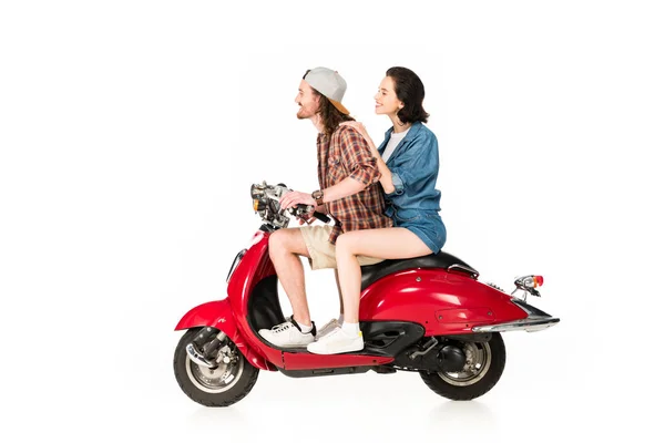 Vue latérale de la fille et du jeune homme regardant vers l'avant, souriant et assis sur scooter rouge isolé sur blanc — Photo de stock