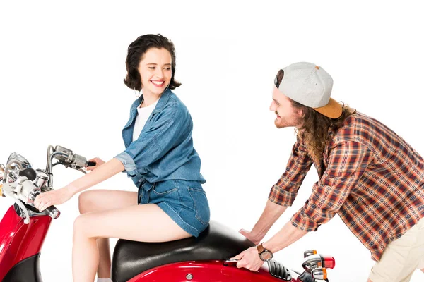 Young man pushing red scooter with girl on it isolated on white — Stock Photo