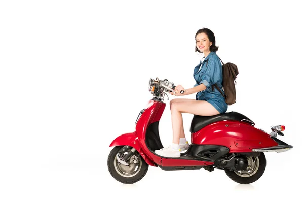 Vue pleine longueur de la fille assise sur scooter rouge isolé sur blanc — Photo de stock