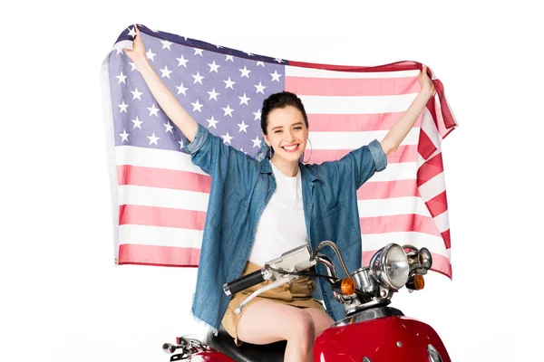 Beautiful girl sitting on red scooter and holding American flag isolated on white — Stock Photo