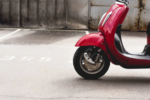 Nouveau scooter rouge debout à l'extérieur dans un endroit ensoleillé — Photo de stock