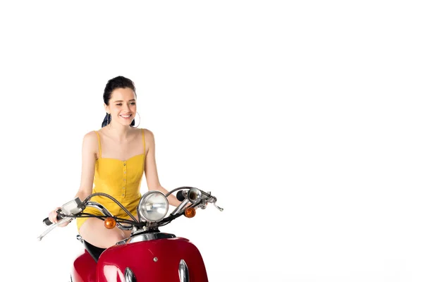 Belle fille assise sur scooter rouge et souriant isolé sur blanc — Photo de stock