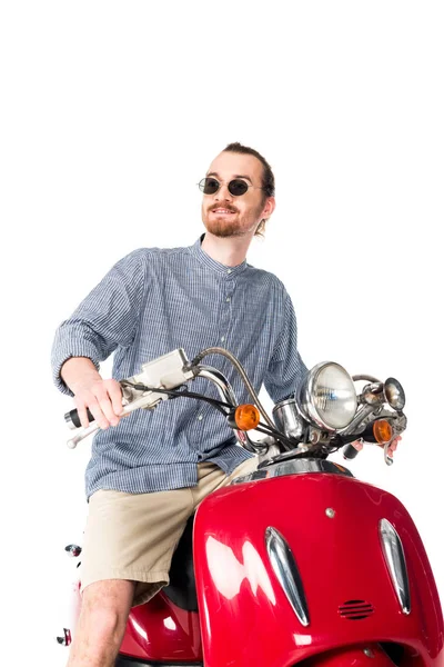 Vista basso angolo di bello elegante giovane seduto su scooter rosso isolato su bianco — Foto stock