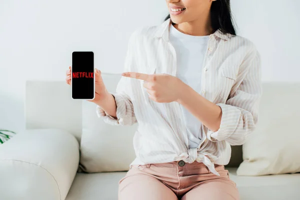 Kyiv, ukraine - 26. April 2019: Schnappschuss einer lateinamerikanischen Frau mit Smartphone und Netflix-App auf dem Bildschirm. — Stockfoto