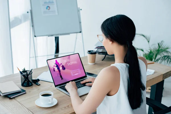 Joven mujer de negocios latina utilizando el ordenador portátil con el sitio web de compras en línea en la pantalla - foto de stock