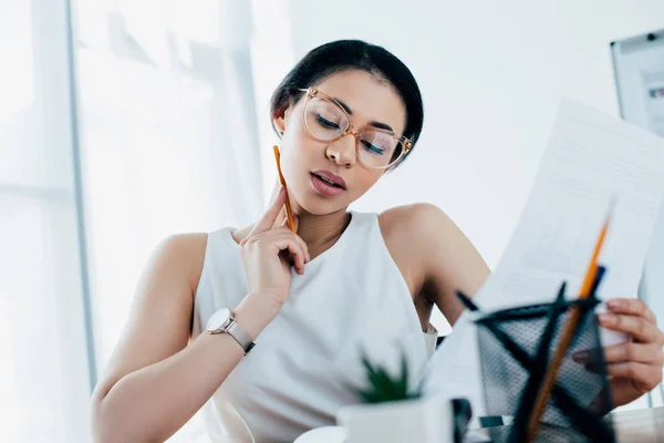 Selective focus of focused latin businesswoman doing paperwork in office — Stock Photo